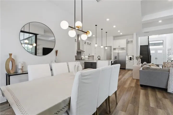 Dining area with dark wood-style flooring and hanging lights