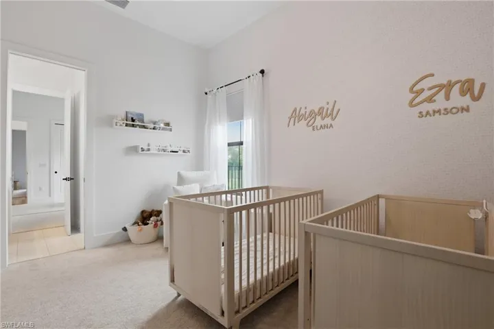 Carpeted bedroom featuring a crib