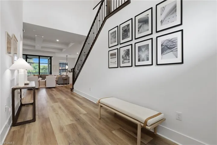 Hall featuring recessed lighting, light wood finished floors, and a high ceiling