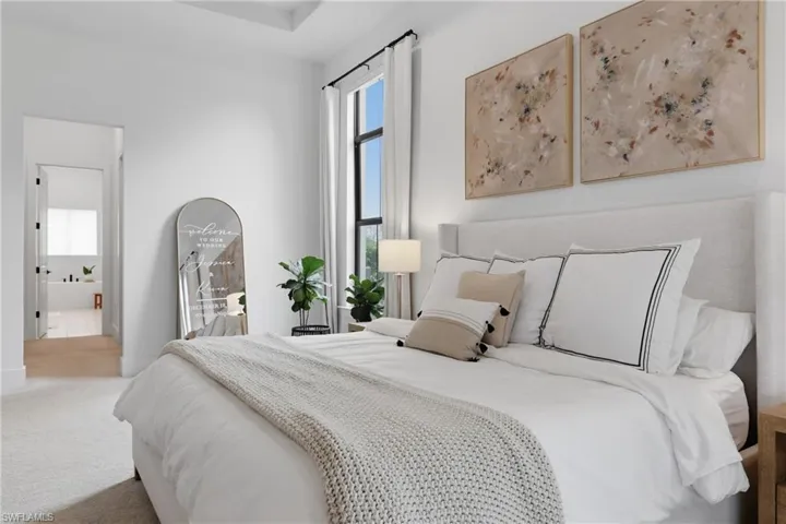Bedroom featuring multiple windows, carpet flooring, and ensuite bath