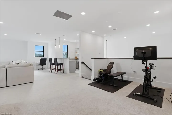 Workout area with light carpet and recessed lighting