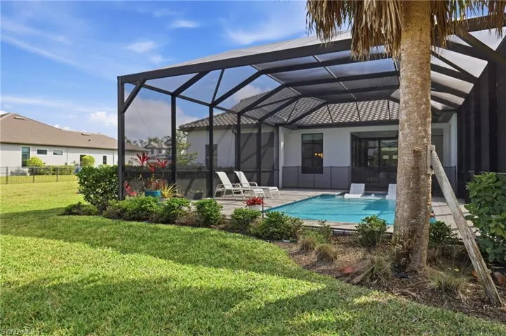 Back of property with a lanai, a sunroom, a patio, an outdoor pool, and stucco siding