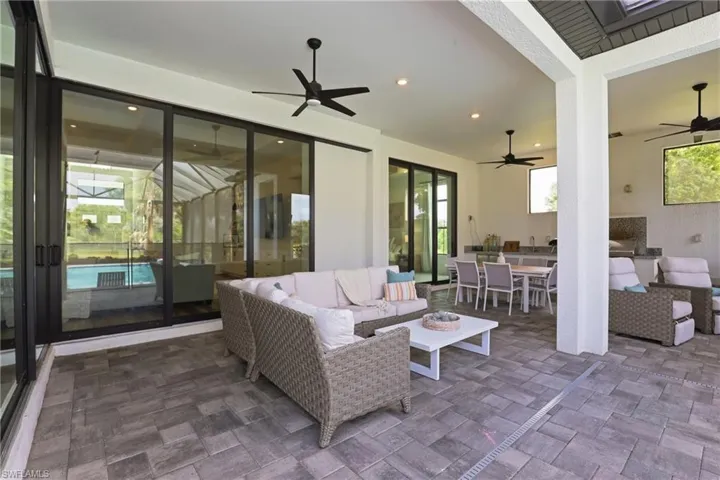 View of patio with an outdoor living / dining area and ceiling fan