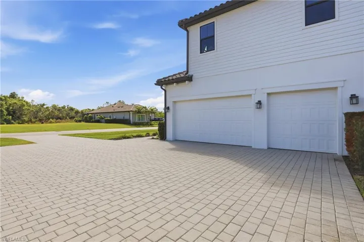 View of home's exterior featuring driveway, a yard, stucco siding, and a tiled roof