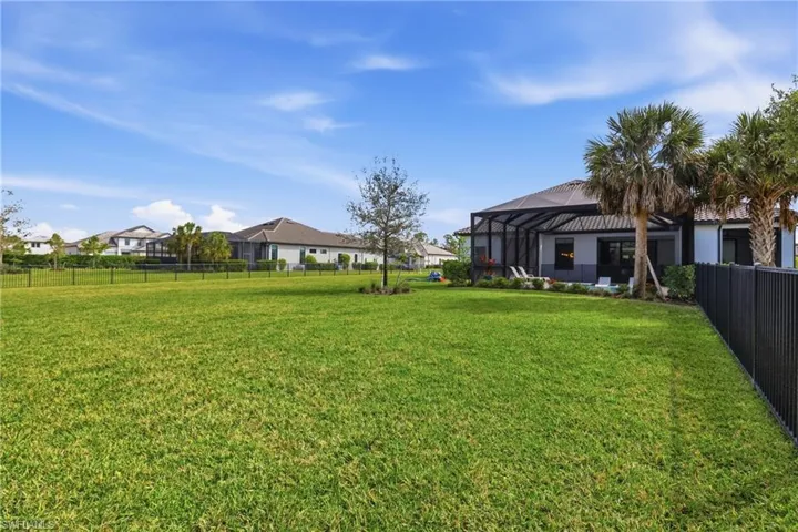 Fenced backyard with glass enclosure and a residential view