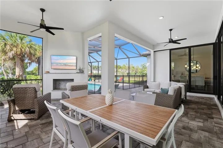 View of patio featuring ceiling fan, a sunroom, outdoor lounge area, and glass enclosure