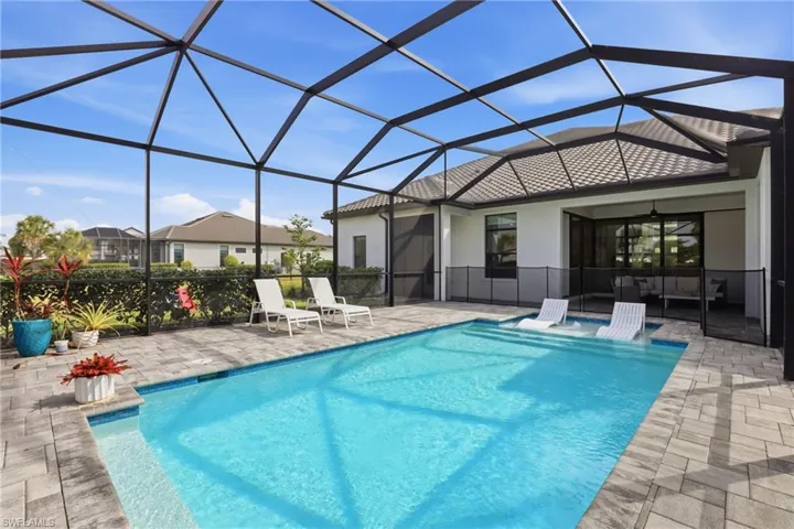 Outdoor pool with a sunroom, glass enclosure, and a patio