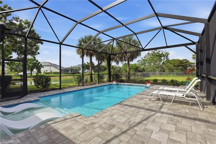 Outdoor pool featuring a sunroom, a patio, and a lanai