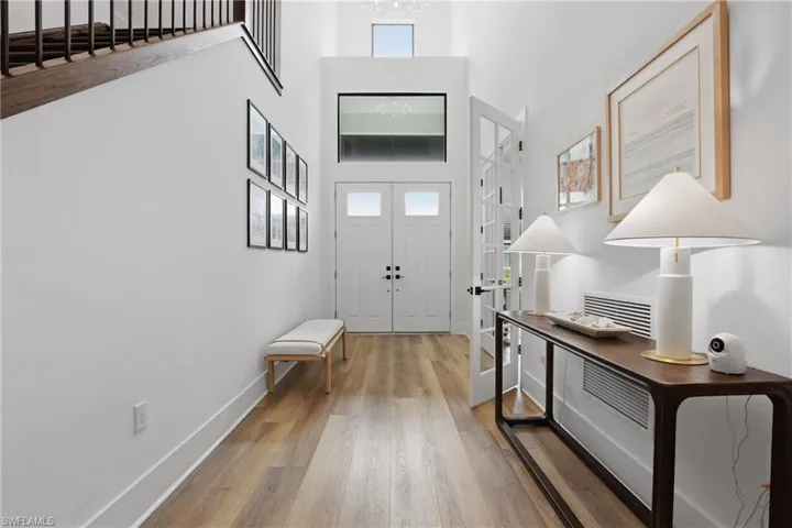 Foyer entrance with wood finished floors and a high ceiling