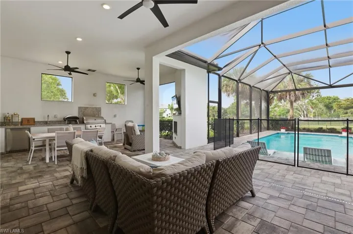 View of patio / terrace featuring area for grilling, a sunroom, an outdoor pool, glass enclosure, and a ceiling fan
