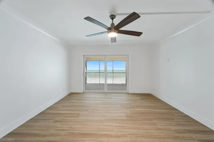 100 Estero BLVD #633_Unfurnished room featuring a ceiling fan, ornamental molding, baseboards, and light wood-style floors