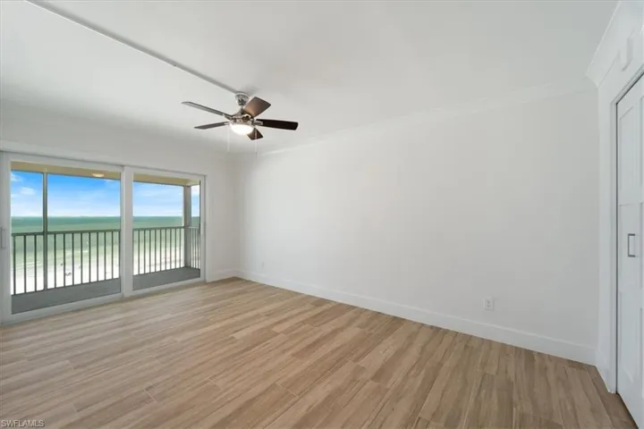 100 Estero BLVD #633_Spare room with a ceiling fan, baseboards, light wood-type flooring, crown molding, and a water view