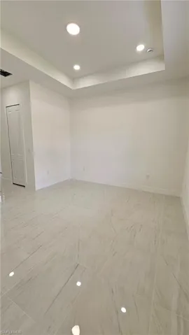 Unfurnished room featuring recessed lighting and a raised ceiling