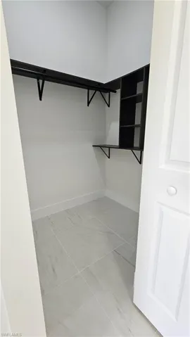 Spacious closet with light tile patterned floors
