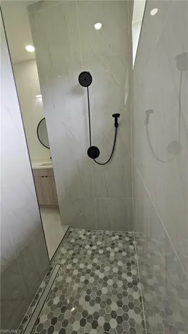 Full bath featuring tiled shower and recessed lighting