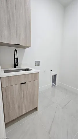 Laundry area featuring hookup for an electric dryer, cabinet space, and hookup for a washing machine