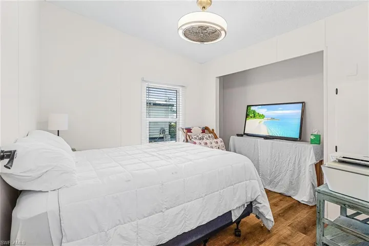 Bedroom with wood finished floors and lofted ceiling