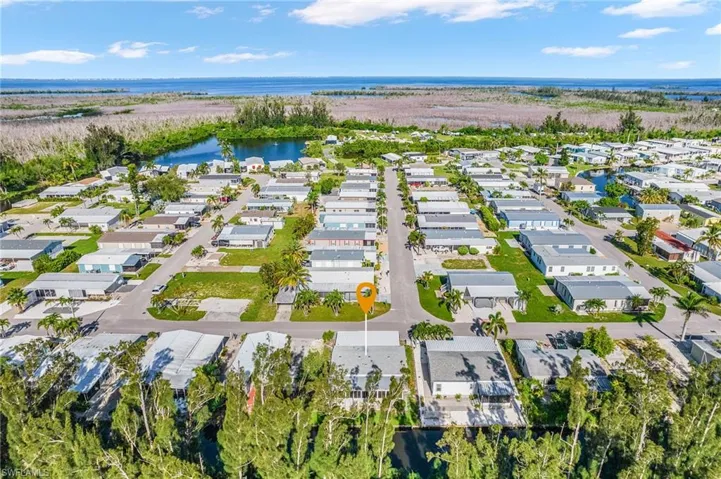 Aerial view of property's location with a nearby body of water and nearby suburban area