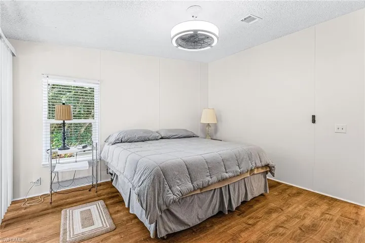 Bedroom with wood finished floors and a textured ceiling
