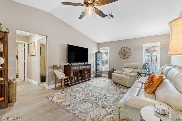 Living room with light wood-type flooring, vaulted ceiling, and ceiling fan