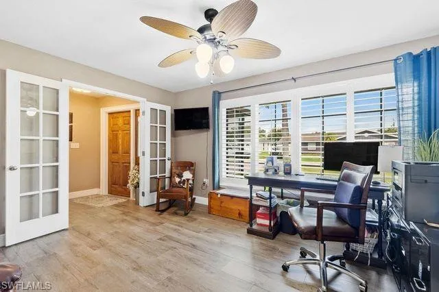 Home office with ceiling fan, french doors, and hardwood / wood-style flooring