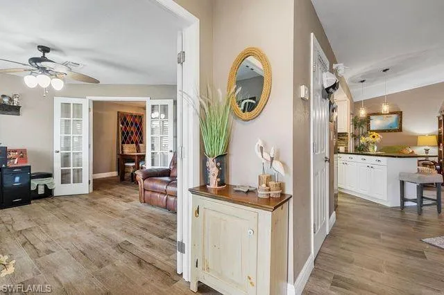 Corridor featuring french doors and wood-type flooring