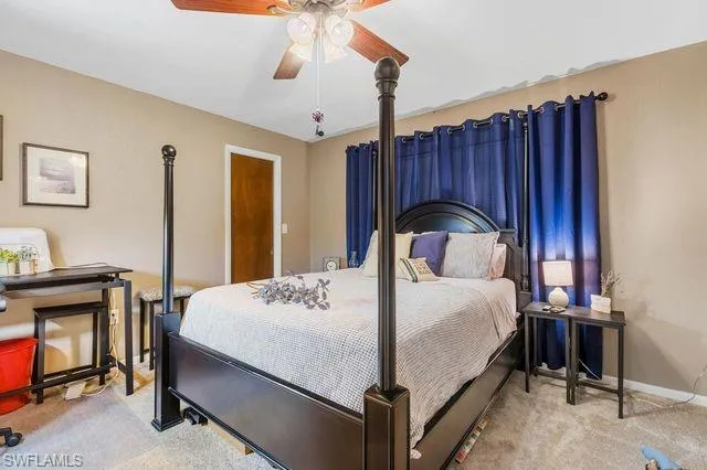 Bedroom with ceiling fan and light colored carpet