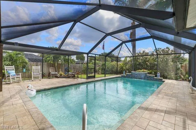 View of pool featuring a patio area, pool water feature, and a lanai