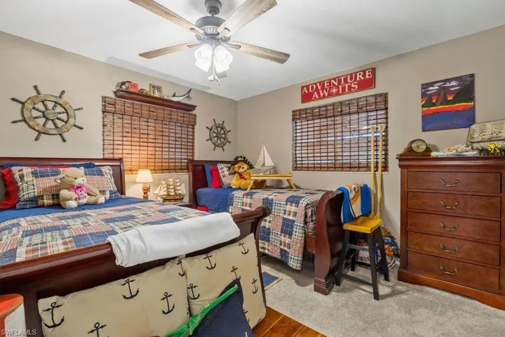 Carpeted bedroom featuring ceiling fan