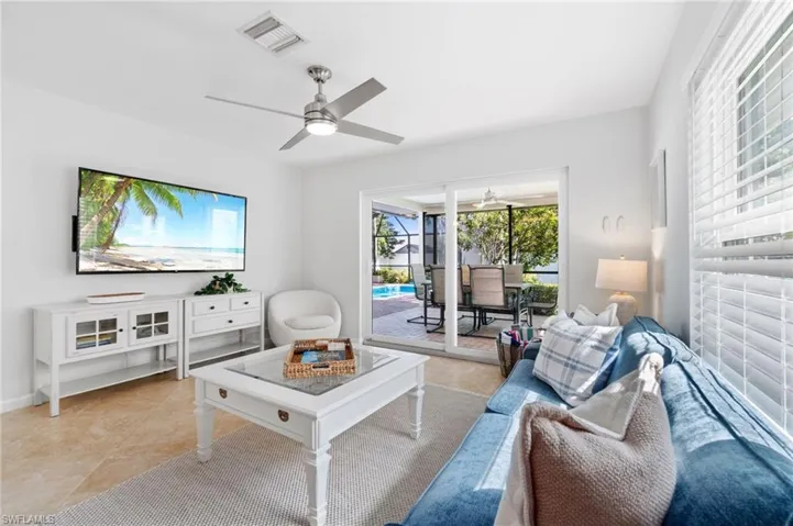 Living room featuring light tile patterned flooring and ceiling fan