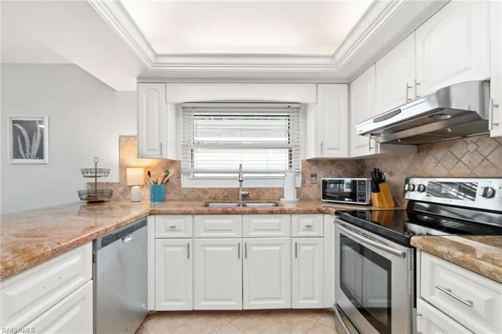 Open kitchen/eat-in counter bar area is light and bright with updated paint and lighting.