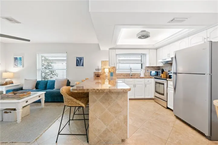 Kitchen opens up to the main living area, freshly painted, and new wind impact windows.