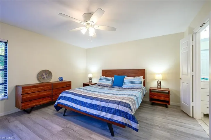 Bedroom featuring multiple windows, light wood-type flooring, and ceiling fan