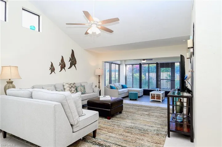 Living area featuring a ceiling fan and high vaulted ceiling