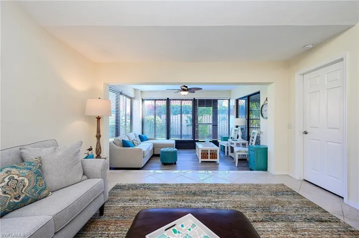 Living room with light tile patterned floors and ceiling fan