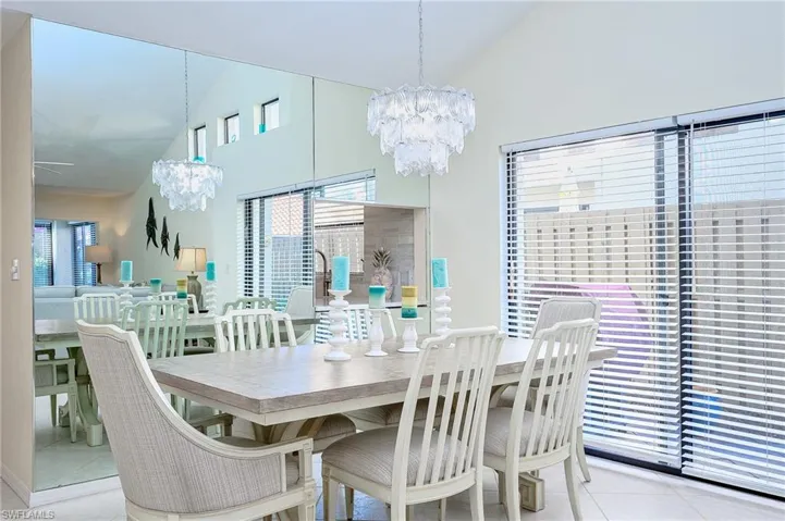 Dining room with vaulted ceiling, a chandelier, and light tile patterned floors