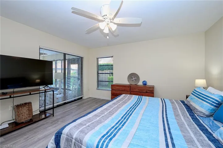 Bedroom with wood finished floors, a ceiling fan, and access to exterior