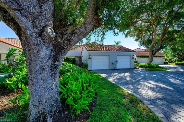 Mediterranean / spanish home featuring a tile roof, decorative driveway, stucco siding, and an attached garage