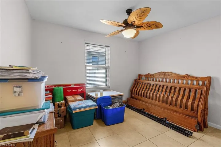 Tiled bedroom featuring baseboards and a ceiling fan