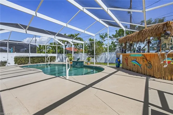 View of pool with glass enclosure, a fenced in pool, a patio area, and fence