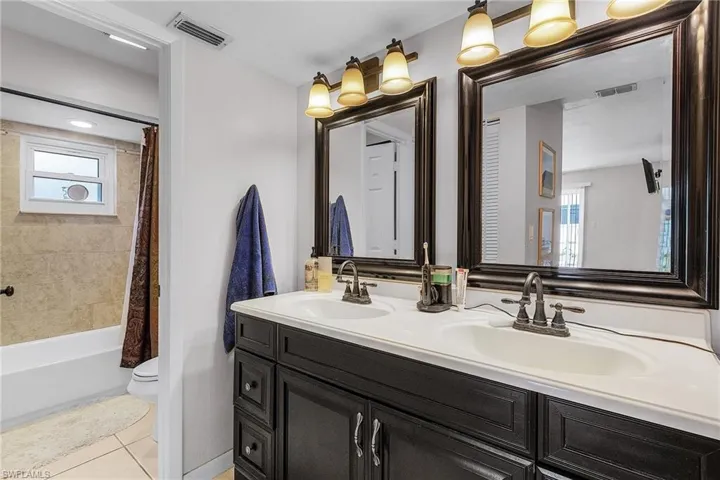 Full bathroom featuring tile patterned flooring, visible vents, toilet, and a sink