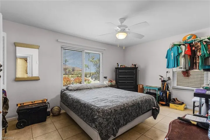 Tiled bedroom with baseboards and a ceiling fan