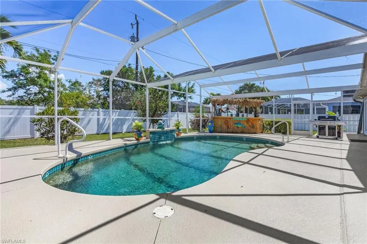 View of swimming pool featuring glass enclosure, a patio area, a fenced backyard, and a fenced in pool