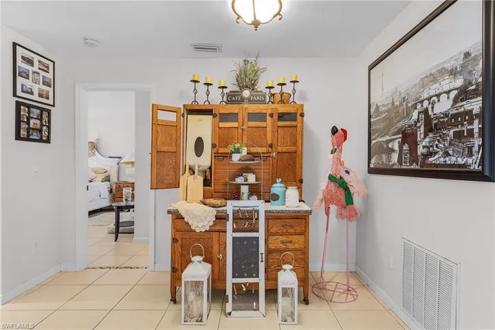 Tiled dining space featuring visible vents and baseboards