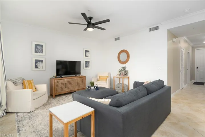 Living room with ceiling fan and ornamental molding