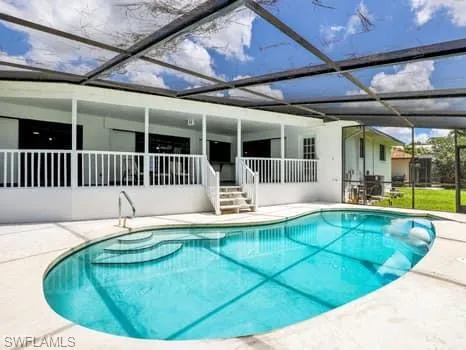Swimming pool with a patio, a sunroom, and a lanai