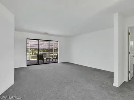 Empty room featuring light colored carpet and baseboards