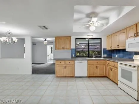 Kitchen featuring white appliances, backsplash, a ceiling fan, and light brown cabinets