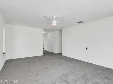 Spare room with ceiling fan and carpet floors