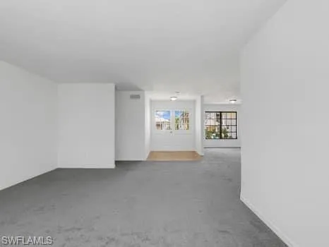 Spare room with carpet and baseboards